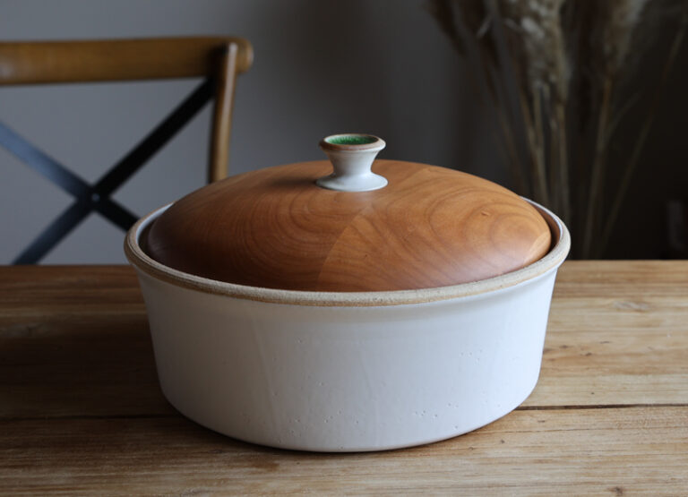 Eine Ton-Brot-Schale mit Holzdeckel und Knopfgriff.