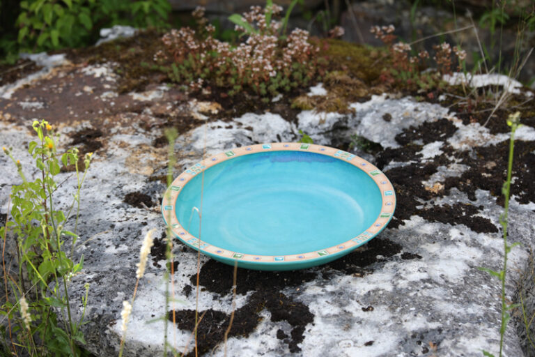 Tonschale auf einem mit Moos bewachsenden Stein.